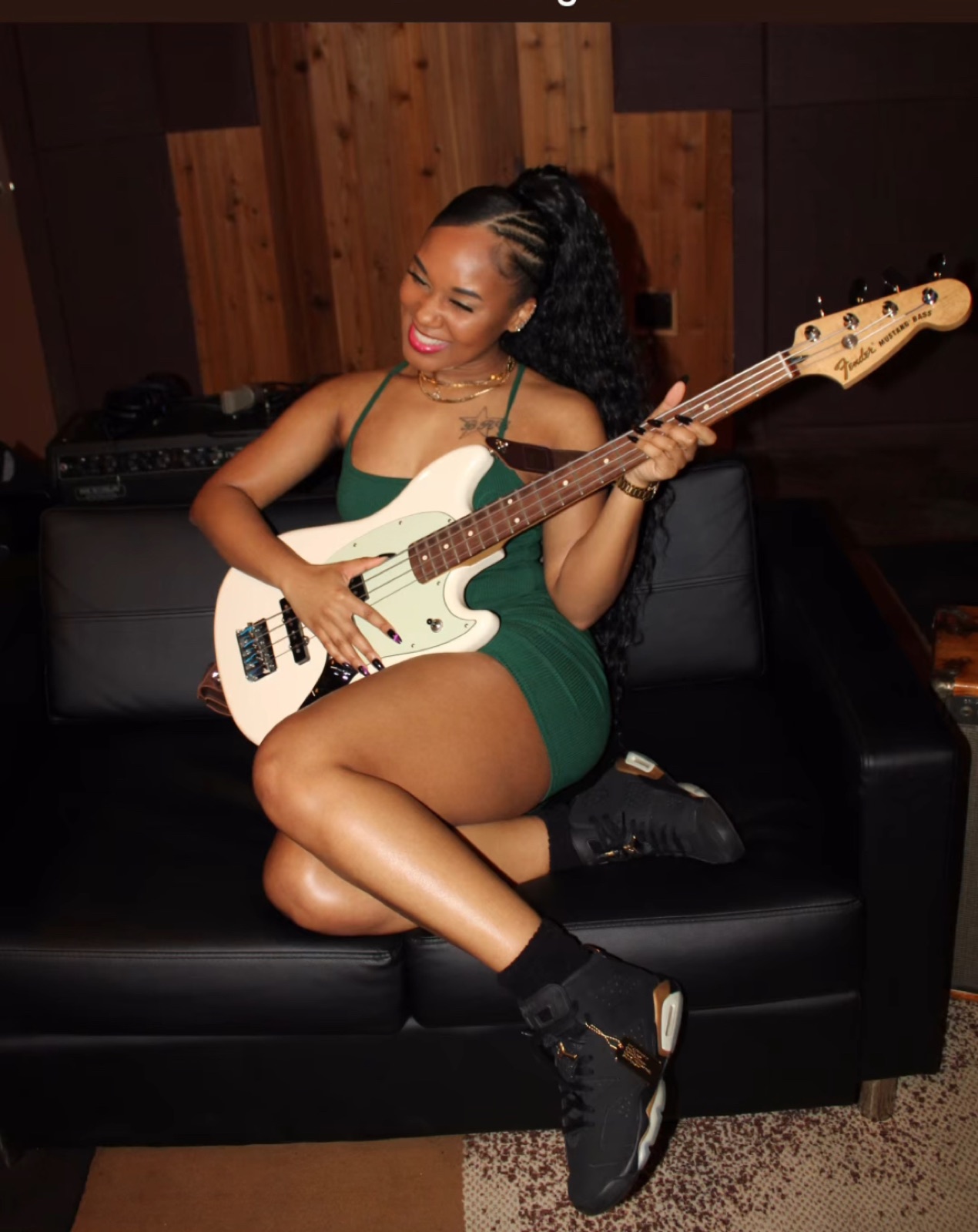 Breezy BRG smiling with a bass guitar in a recording studio